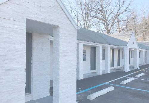 a white brick building with a parking lot at Ramsey Inn & Suites in Ramsey