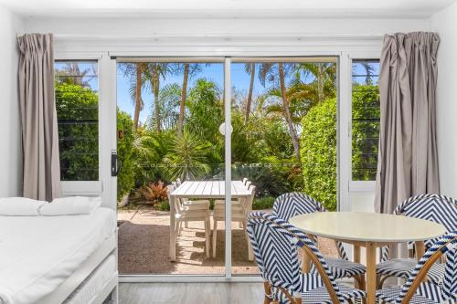 a room with a bed and a table and chairs at Rosslyn Bay Resort Yeppoon in Yeppoon
