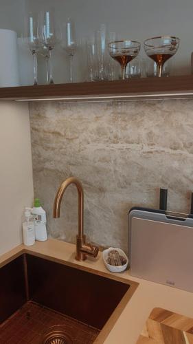 a kitchen counter with a sink and some wine glasses at Le Maroc at Bar Beach in Newcastle