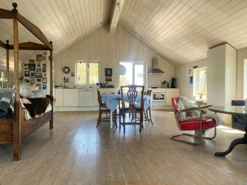 a living room with a dining table and a kitchen at Architect-Designed House With Pier In Ny Hellesund in Søgne