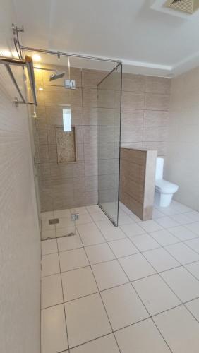 a bathroom with a shower and a toilet at Morgah Resort - Guest Rooms in Rawalpindi