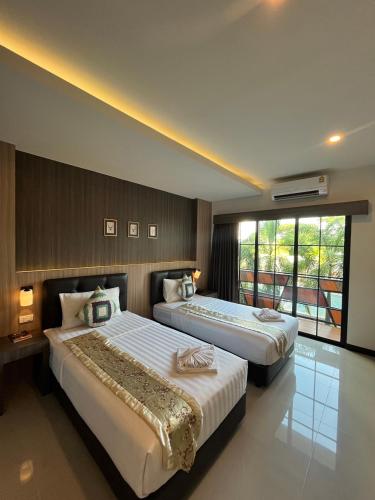 a hotel room with two beds and a window at The Room Boutique Hotel in Sakon Nakhon