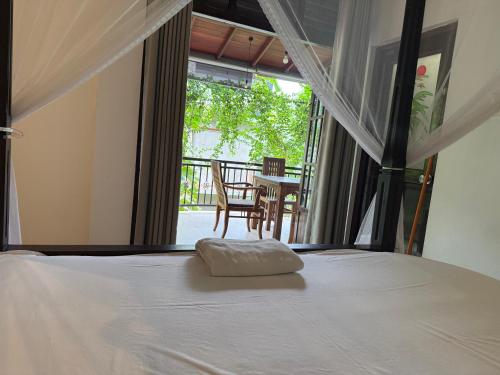 a bedroom with a bed with a view of a patio at Tanzanite place in Tangalle