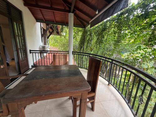 a wooden table and chairs on a balcony at Tanzanite place in Tangalle