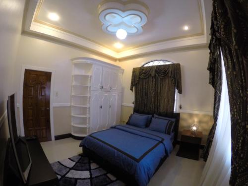 una camera con letto blu di The Executive Villa Inn & Suites a Davao