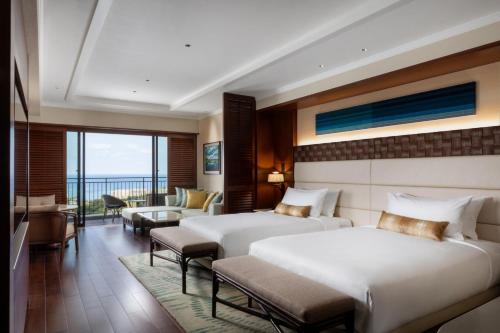 a hotel room with two beds and a balcony at PGM Hotel Resort Okinawa in Onna