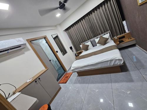 a bedroom with a king sized bed and a mirror at Hotel Royal Heritage in Gandhinagar