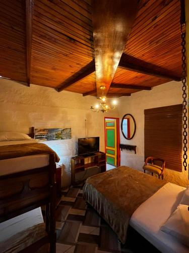 a bedroom with two beds and a television in a room at Casa de La Abuela Irene in Calarcá