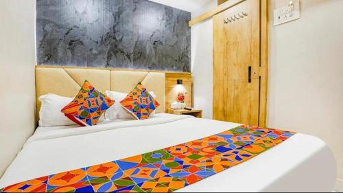 a bedroom with a large bed with a colorful blanket at Hotel Baghdad Palace in Mumbai