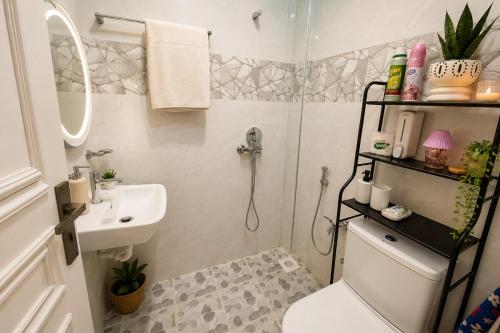 a bathroom with a shower and a toilet and a sink at Kai Apartments Near Airport Zanzibar in Zanzibar City