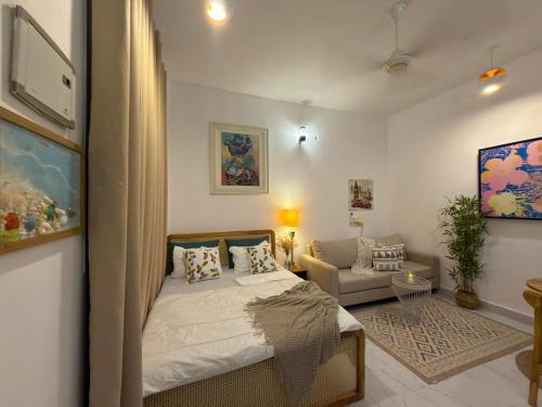 a bedroom with a bed and a living room at Kai Apartments Near Airport Zanzibar in Zanzibar City