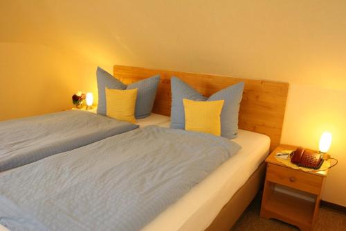 a bedroom with a bed with blue and yellow pillows at Hotel Krone Rüdesheim in Rüdesheim am Rhein