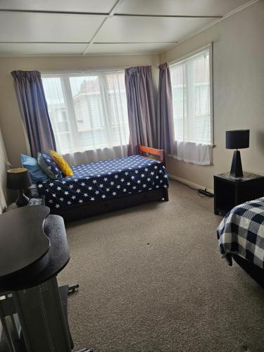 a bedroom with two beds and two windows at Kiwi bnb in Matamata