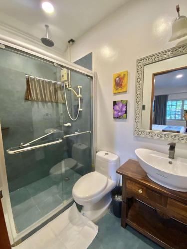 a bathroom with a shower and a toilet and a sink at Commander Suites de Velada in Antipolo