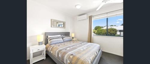a bedroom with a bed and a large window at Terrapin Apartment 4 in Noosaville