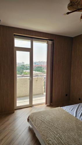 a bedroom with a bed and a large window at Sayram in Yunusobod
