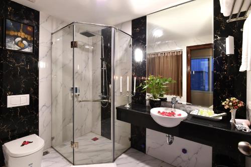 een badkamer met een douche, een toilet en een wastafel bij Hanoi Eternity Hotel in Hanoi