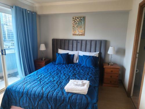 a bedroom with a blue bed with blue pillows at The Sedgebrook On Leichhardt in Brisbane