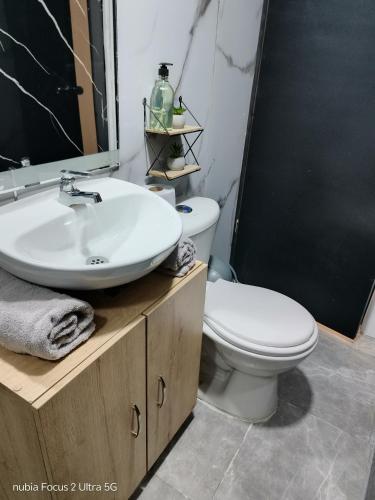 a bathroom with a white toilet and a sink at Room cerca al aeropuerto #3 in Bogotá