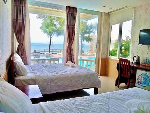 a hotel room with two beds and a view of the ocean at Hai Yen Family Hotel in Mui Ne