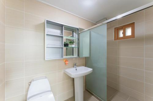 a bathroom with a toilet and a sink at U&I Pension in Yangyang