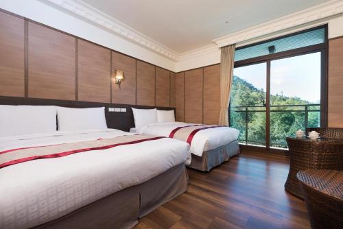 two beds in a hotel room with a large window at Fantasy Palace in Yuchi