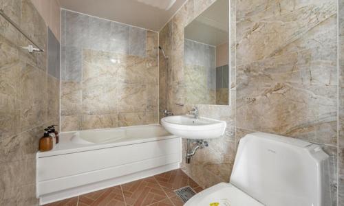 a bathroom with a sink and a toilet and a bath tub at Mud Beach Hotel in Boryeong