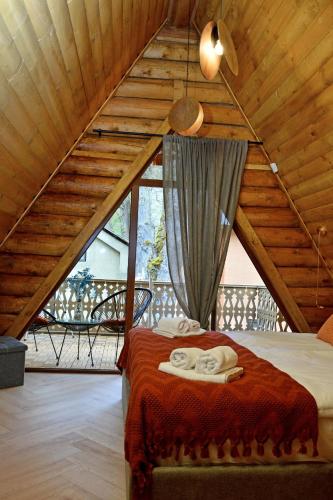 a bedroom with a bed in a wooden attic at Cottages Vakhrama in Abastumani
