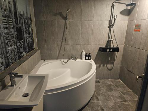 a bathroom with a white tub and a sink at Ocean View Haute Hotel in Busan