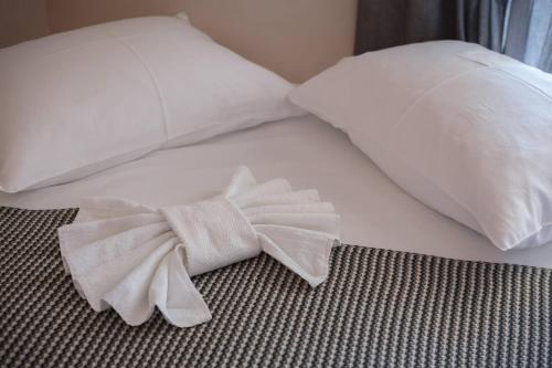 a white bed with a bow tie on it at Apartments Barbarić in Zaostrog