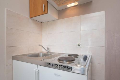 a kitchen with a sink and a stove at Apartments Barbarić in Zaostrog
