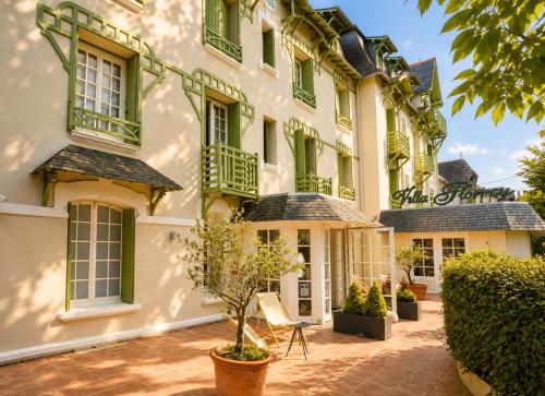 an exterior view of a building with green shutters at Hôtel Villa Flornoy Pornichet Baie de la Baule in Pornichet