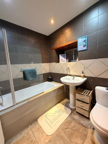 a bathroom with a tub and a sink and a toilet at Kassandra's Cottage in Vasa