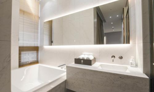 a bathroom with a tub and a sink and a mirror at Uiwang Milos Hotel in Uiwang