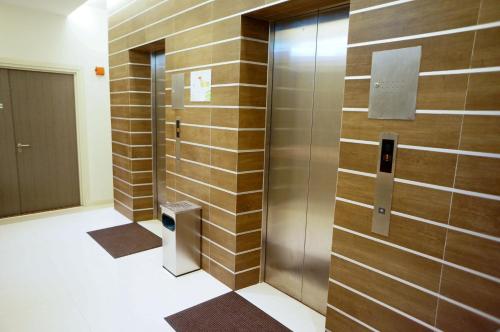 a bathroom with wooden walls and a metal elevator at Kosma Business Hotel in Kuantan