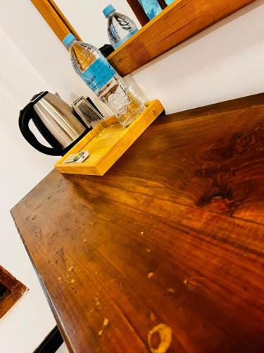 a wooden counter top with a bottle on top of it at Liyana Holiday resort in Anuradhapura