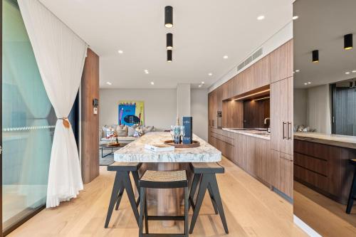 a kitchen with a large island with a marble counter top at Casa Celeste, Grand Architectural Residence in Wollongong