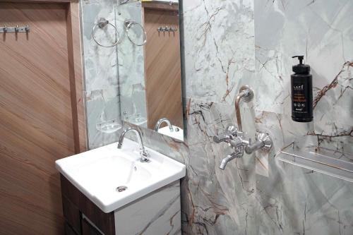 a bathroom with a sink and a mirror at Hotel Konark INN in Bareilly