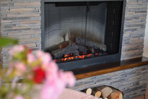 a brick fireplace with a fire in it at Cincis by the Lake in Cinciş