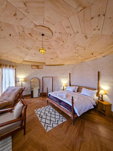 a large bedroom with a large bed and a couch at BSR Farms Resort in Pauri