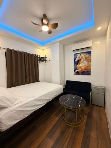 a room with a bed and a couch and a ceiling fan at Manatad Transient Deluxe Room 2 in Surigao