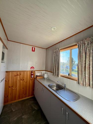 a kitchen with a sink and a window at Holbrook Motor Village in Holbrook