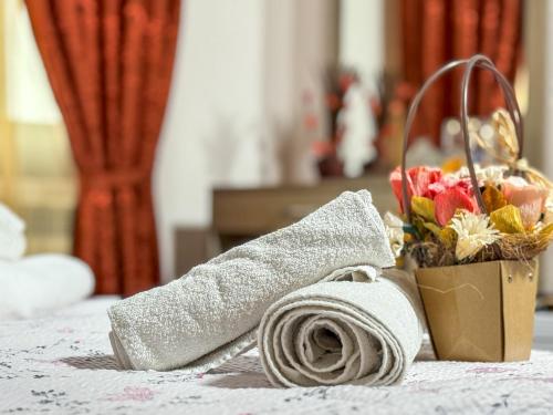 a towel and a basket of flowers on a bed at СТАР МЕРАК in Ribarica