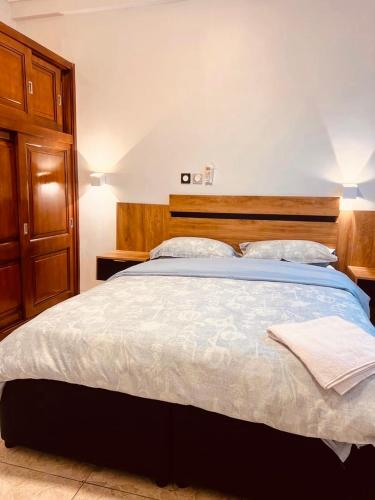 a bedroom with a large bed with a wooden headboard at Egel Appartement in Yaoundé