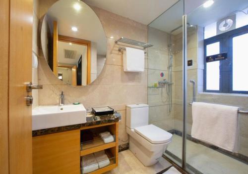 a bathroom with a sink toilet and a mirror at Dan Executive Apartment Guangzhou Zhujiang New Town in Guangzhou