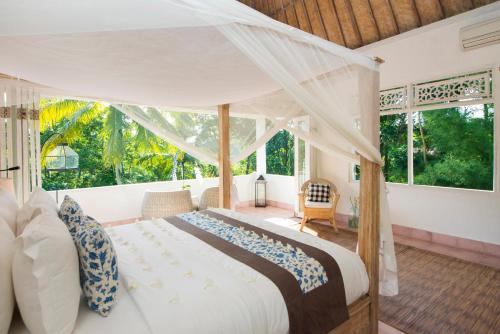 a bedroom with a large bed with a canopy at Shamballa Moon in Ubud