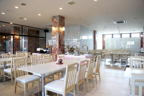 a dining room with white tables and chairs at Asia Hotel Narita in Narita