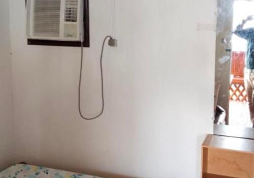 a room with a bed and a microwave on a wall at Cliff Cabanas by Hiverooms in Catmon