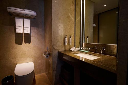 a bathroom with a sink and a mirror at 杭州钱江新城黄龙璀怡酒店 凯悦尚选 in Hangzhou