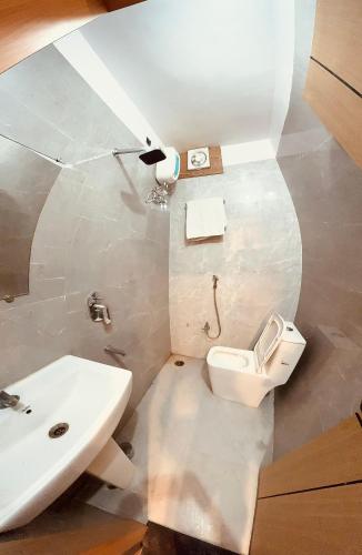 a bathroom with a white toilet and a sink at Hotel The Edge in Rewa